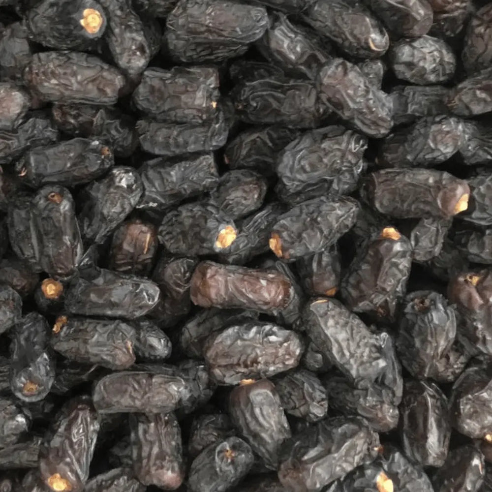 kalmi/Qalmi Dates spread out in a cart, highlighting their distinctive wrinkled appearance